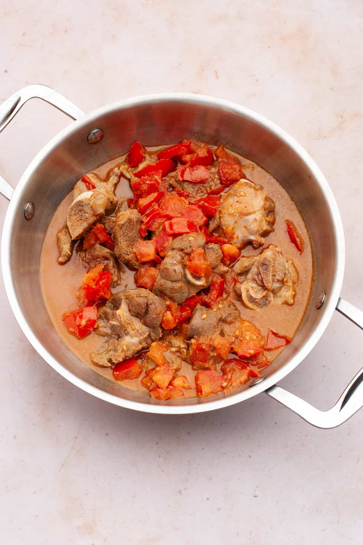 lamb cooking with tomatoes in a wok