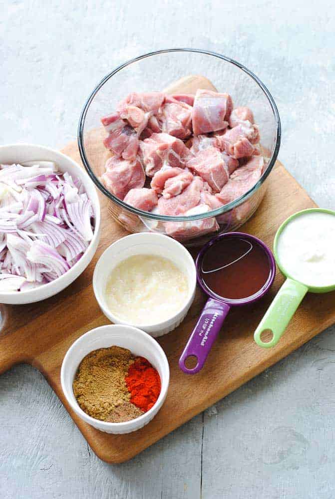 ingredients - mutton, yogurt, oil, ginger-garlic paste, spices and onions