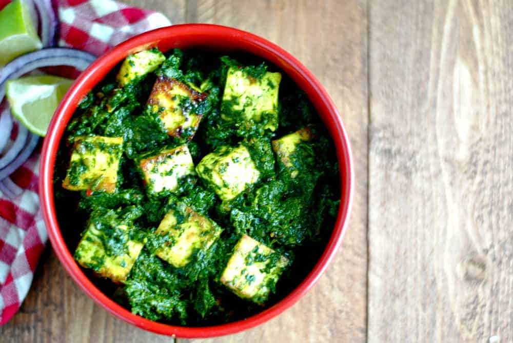palak paneer in a dish with salad on the side