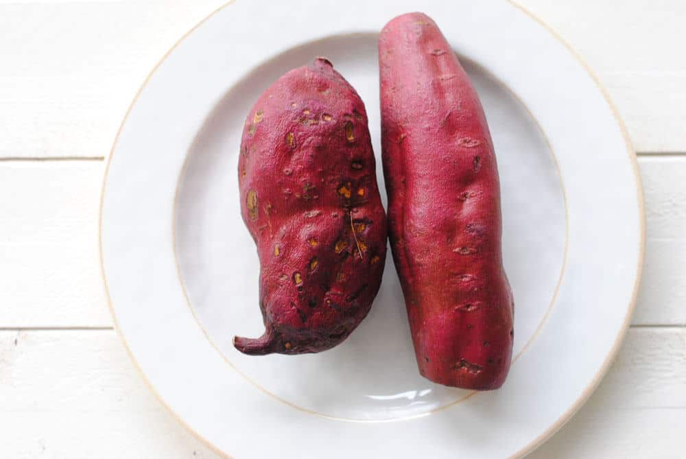 Two long sweet potatoes on a plate. 