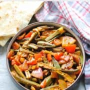 bhindi masala in a bowl with Indian bread on the side