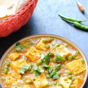 matar paneer in a bowl and a bread basket