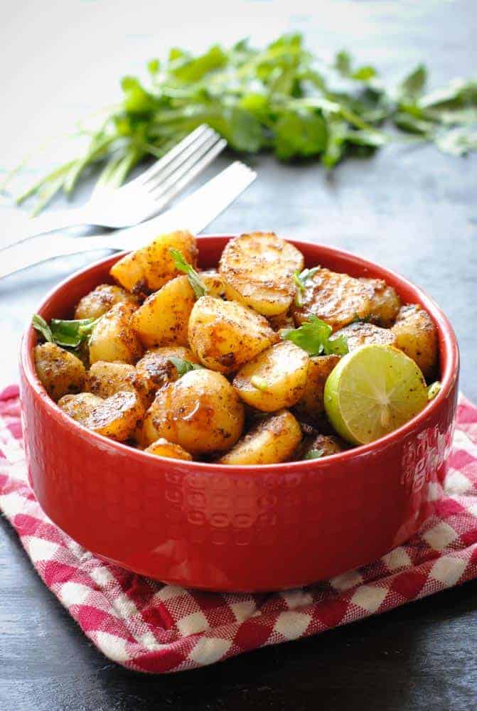 Aloo Chaat in (potato salad) in a bowl with cilantro and a lemon wedge