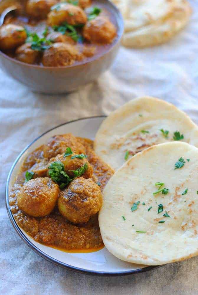 Dum aloo in a plate with naan bread