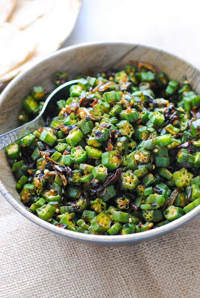 bhindi sabzi in a bowl with naan on the side