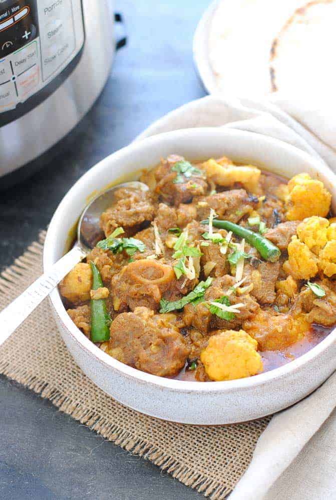 Gobi gosht in a bowl with an instant pot on the side