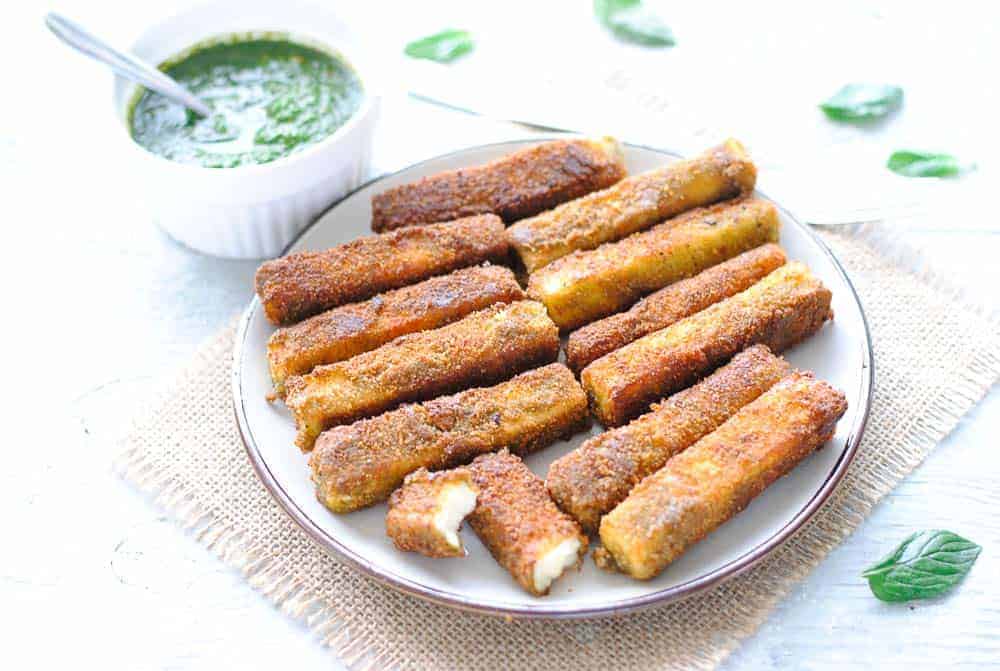 paneer fingers on a plate with green chutney on the side