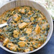 palak chicken in a bowl with a spoon