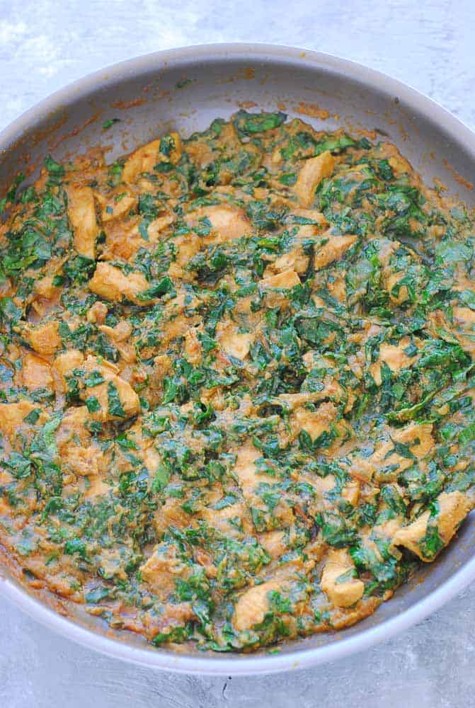 palak chicken cooking in a pan