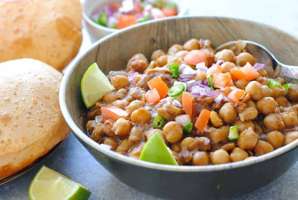 punjabi chole in a bowl with poori on the side
