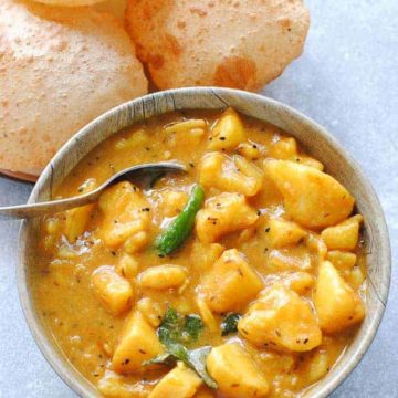 aloo curry in a bowl with poori on the side