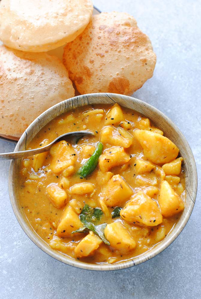 aloo curry in a bowl with poori on the side