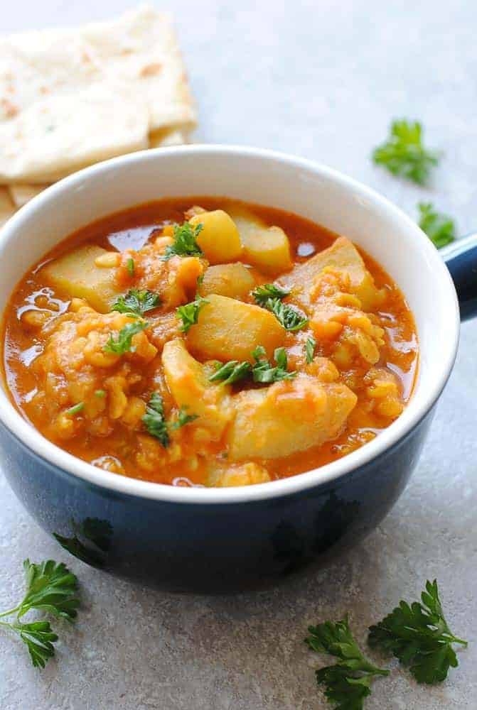 lauki chana dal in a blue bowl with roti on the side