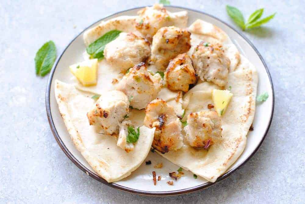 chicken malai tikka over Indian bread in a plate