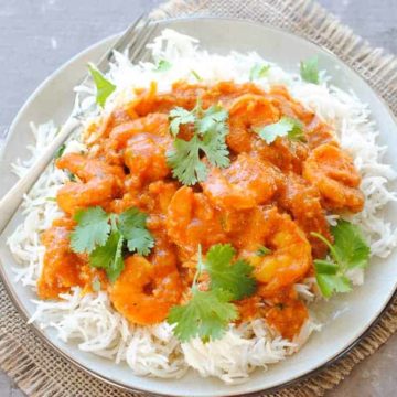 coconut shrimp curry over rice in a plate