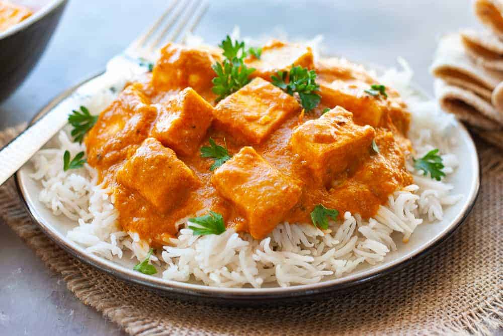 paneer curry over rice in a plate