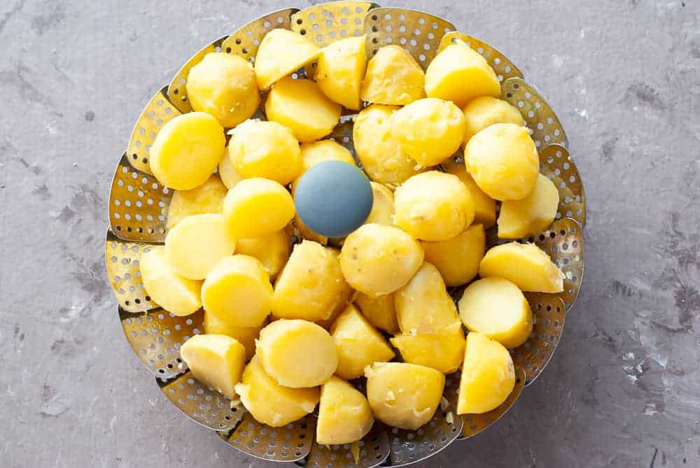 boiled and halved baby potatoes in steamer basket