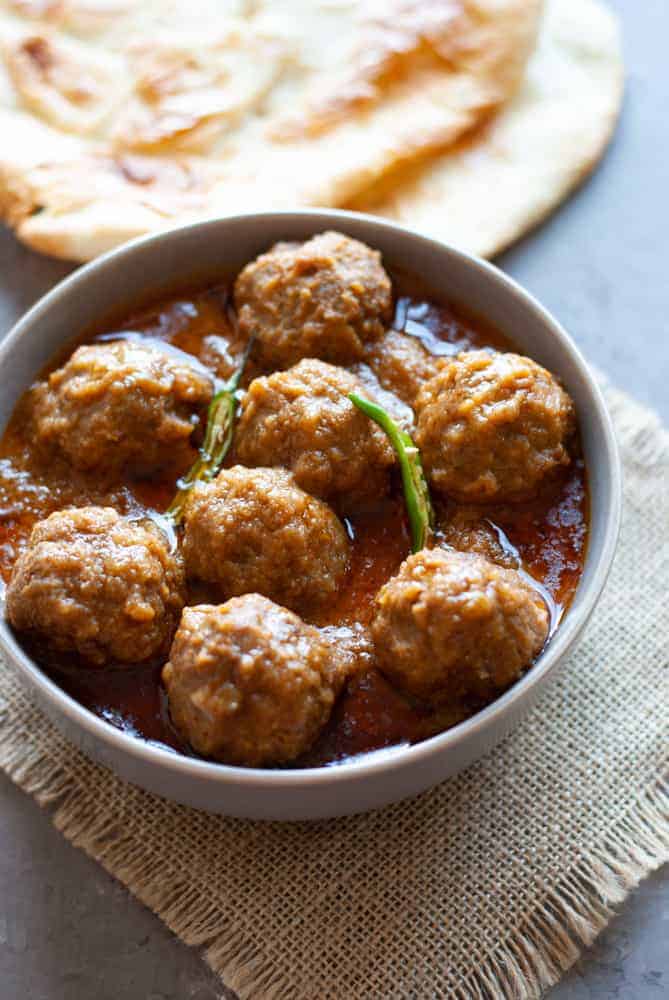 kofta curry (meatballs in sauce in a bowl with naan on the side