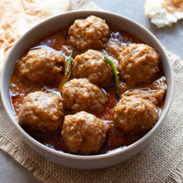 kofta curry in a bowl with naan on the side