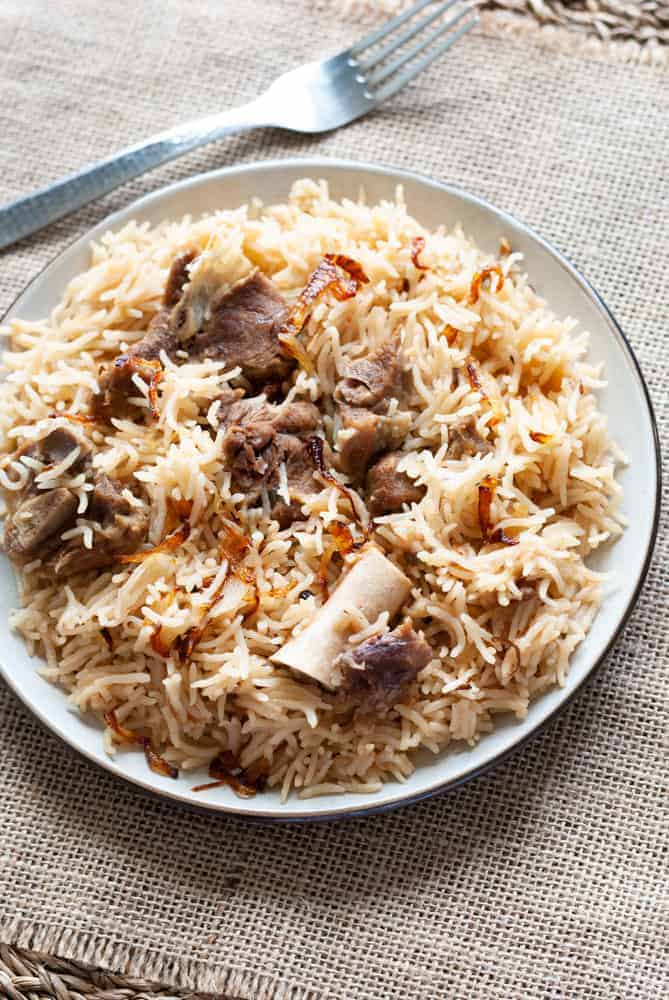 yakhni pulao in a plate with a fork on the side