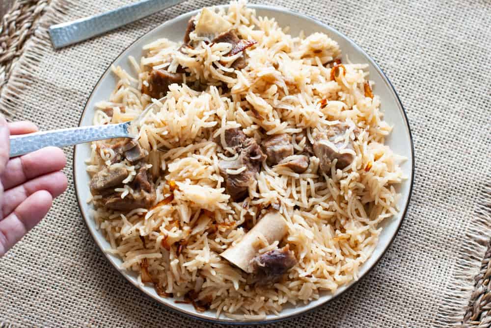yakhni pulao in a plate with a fork