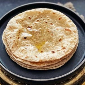 a stack of rotis or chapatis on a platter.