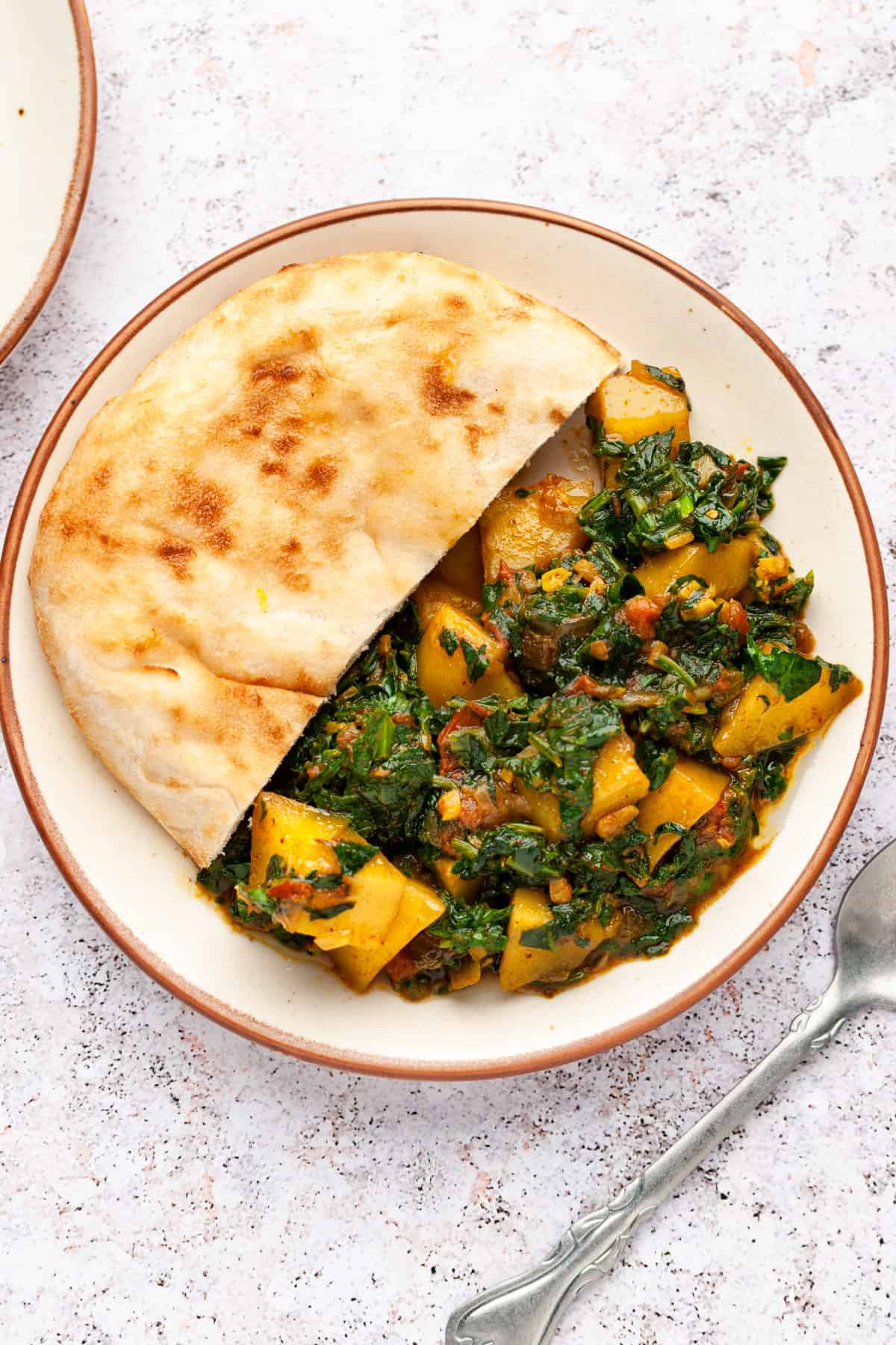 potato and spinach curry in two bowls 