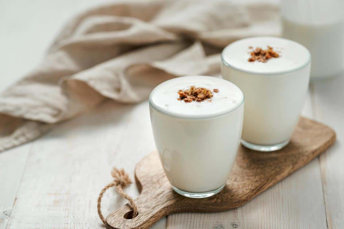 Lassi in two glasses on a wooden board.