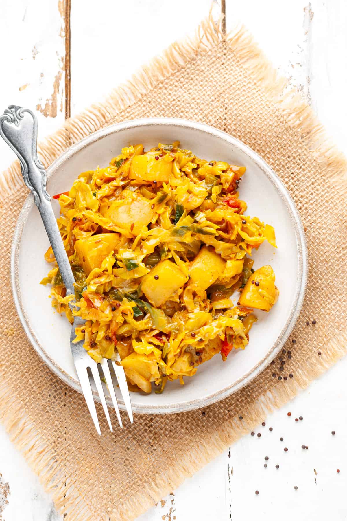 dry cabbage and potato sabzi in a plate with fork