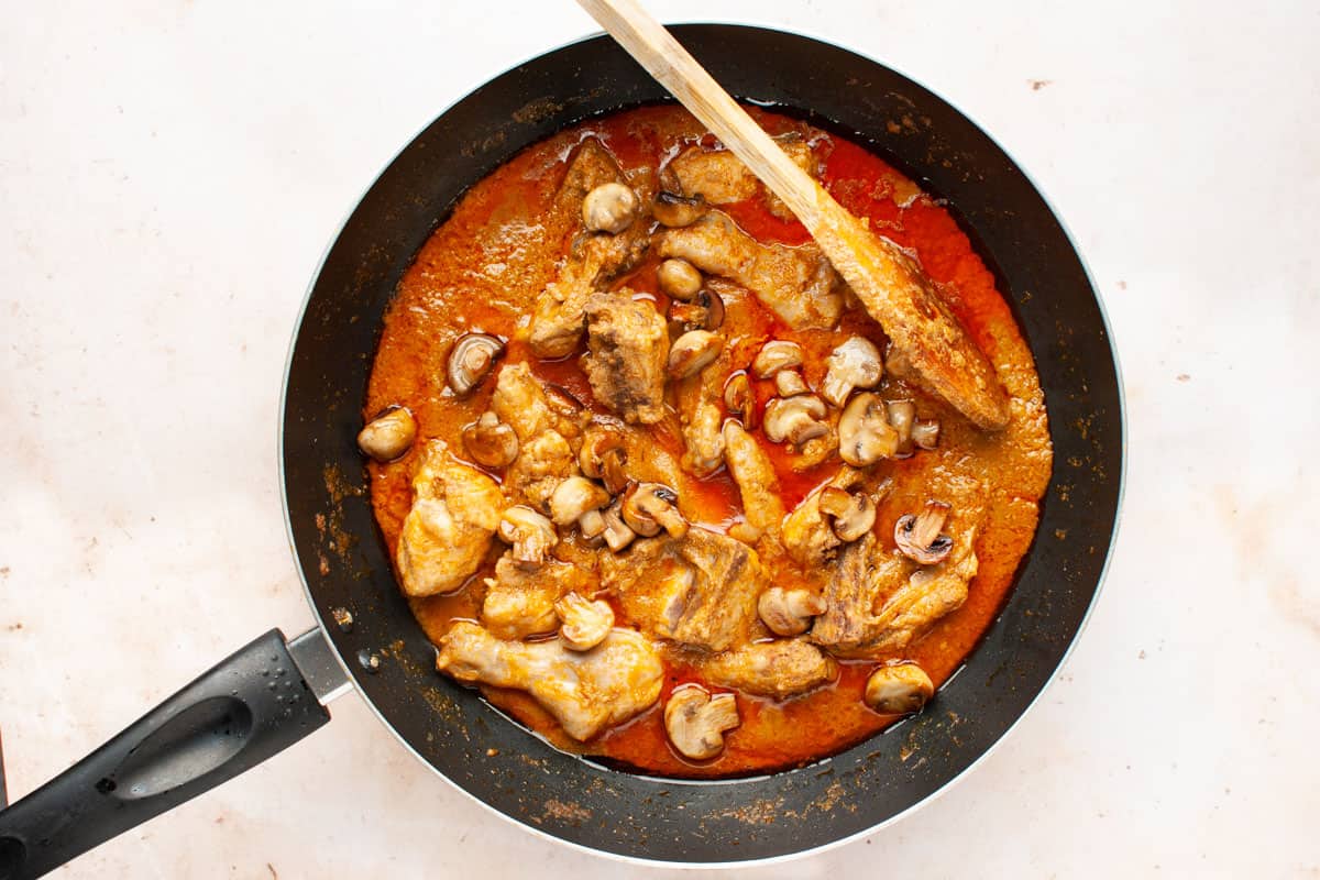 Chicken and mushroom curry in a pan.