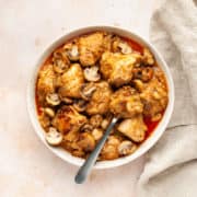 chicken and mushroom curry in a bowl with a spoon