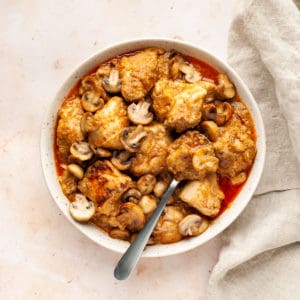 chicken and mushroom curry in a bowl with a spoon