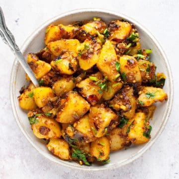 dry aloo sabzi in a bowl with a spoon