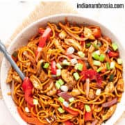 Chicken hakka noodles in a bowl with a fork.