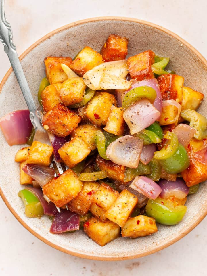 Paneer pepper fry in a bowl with a fork.