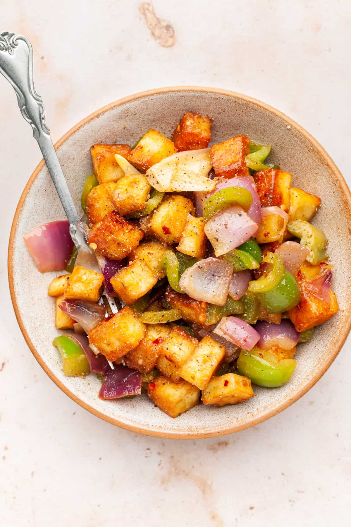 Paneer pepper fry in a bowl with a fork.