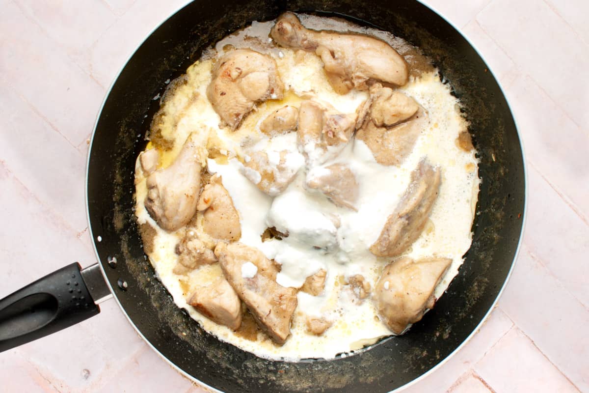white chicken karahi in a pan with cream and yogurt.