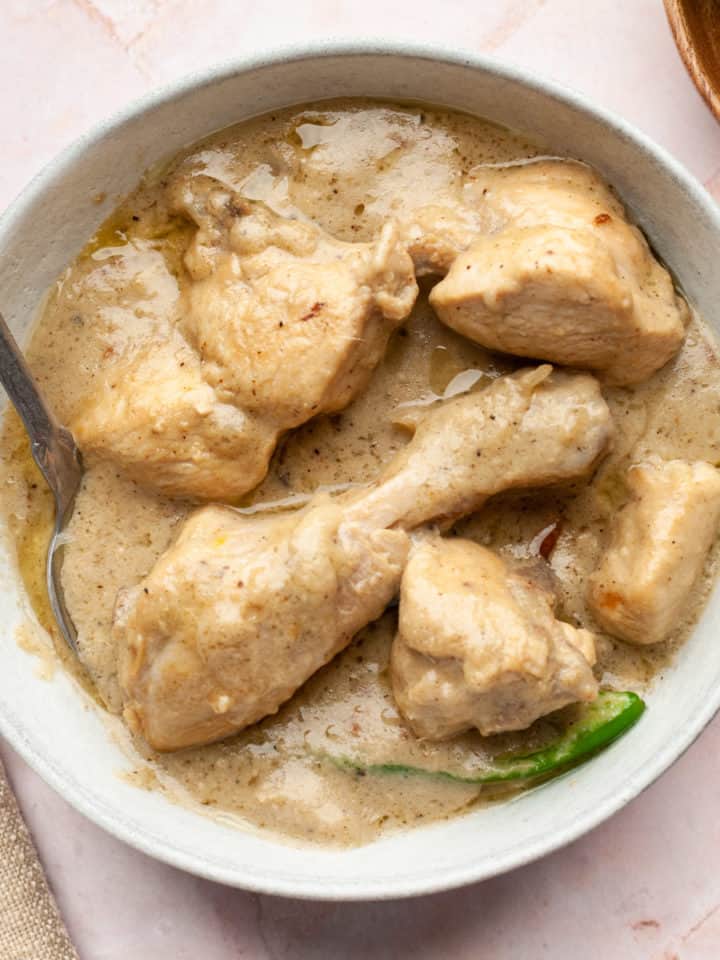 White chicken karahi in a bowl with a spoon.