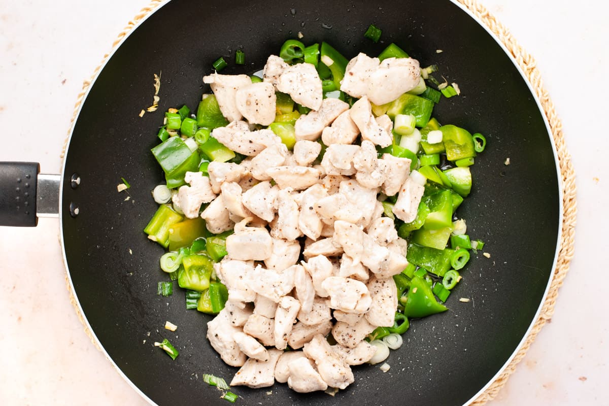 Schezwan chicken step - chicken and vegetables in a wok.