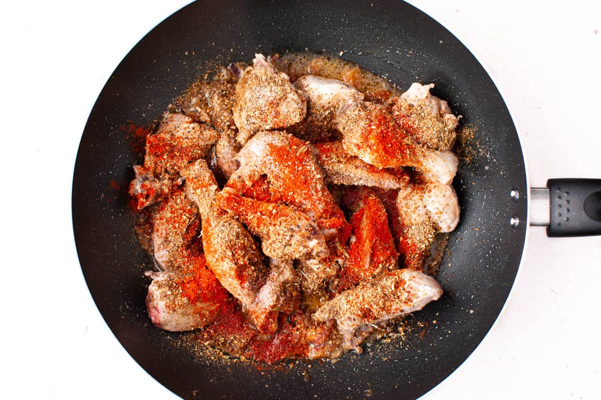 Adding chicken, red chilli powder and salt to the masala in wok.